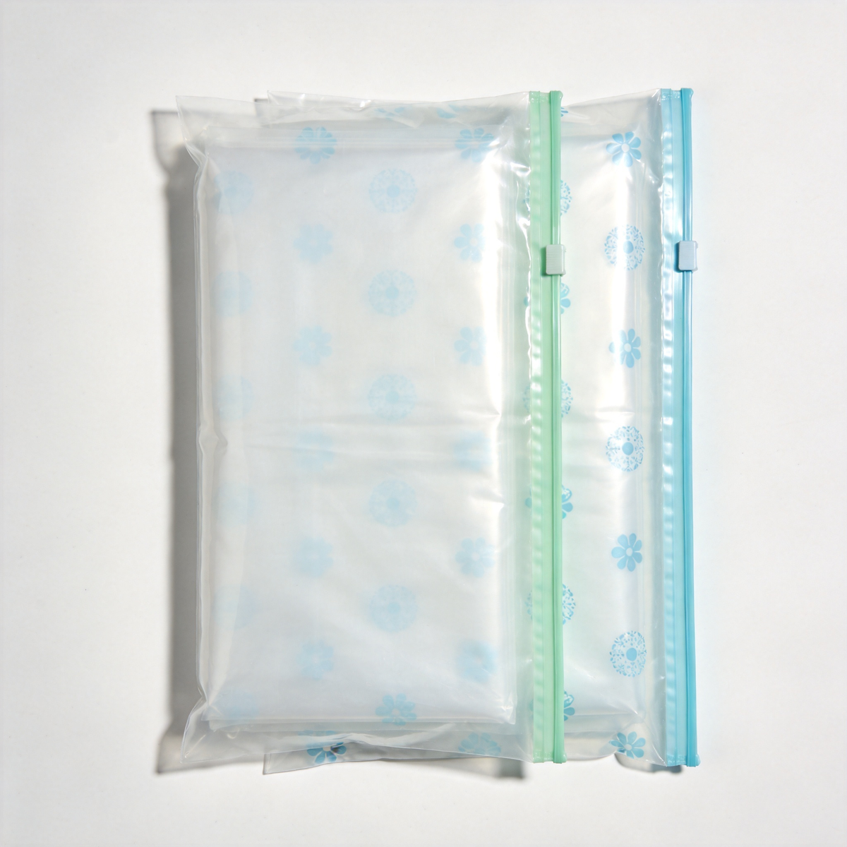 Clear floral zip storage bags with pale blue patterns and mint-green and light-blue zipper closures