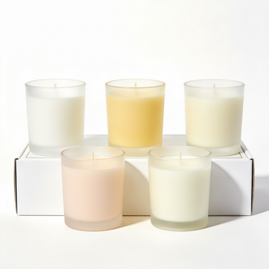 Five frosted glass scented candles in soft neutral and pastel colors on a white background